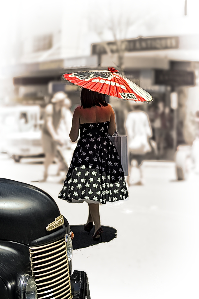 Woman shaded by a parasol on a blazing hot day